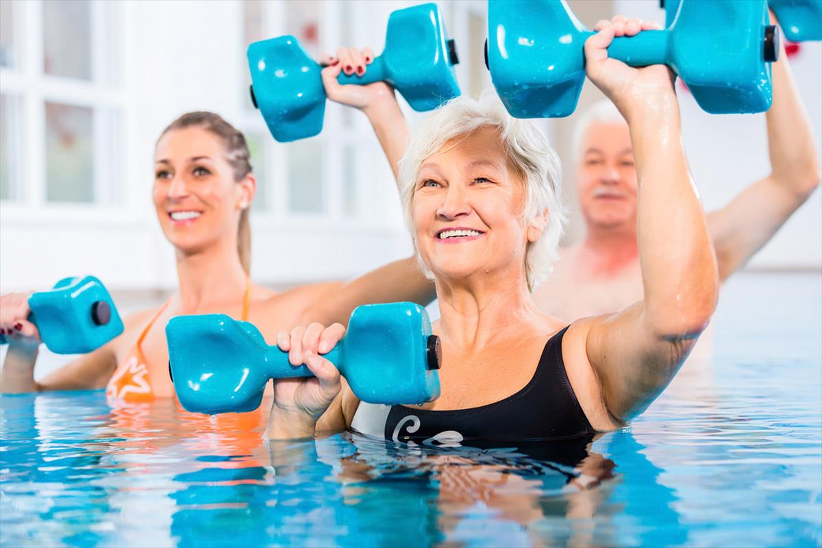 Gäste mit Hanteln bei der Wassergymnastik im Sportbecken